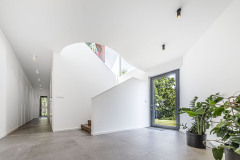 Centrum domu s triezvou pravouhlou architektúrou „oslňujú“ oblé krivky otvoreného schodiska. Denné svetlo, ktoré sem prichádza z niekoľkých strán, zvýrazňuje jeho jemné tvary