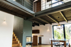 Vnútorné usporiadanie je úplne moderné. Drevený trámový strop a galéria nad spoločnou obývacou časťou akoby sa voľne vznášali v priestore. Strešnými oknami i oknom v štíte preniká veľa svetla